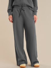 Person wearing gray sweatpants and a matching top on a beige background