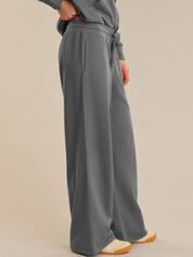 Person wearing gray wide-leg pants on a beige background