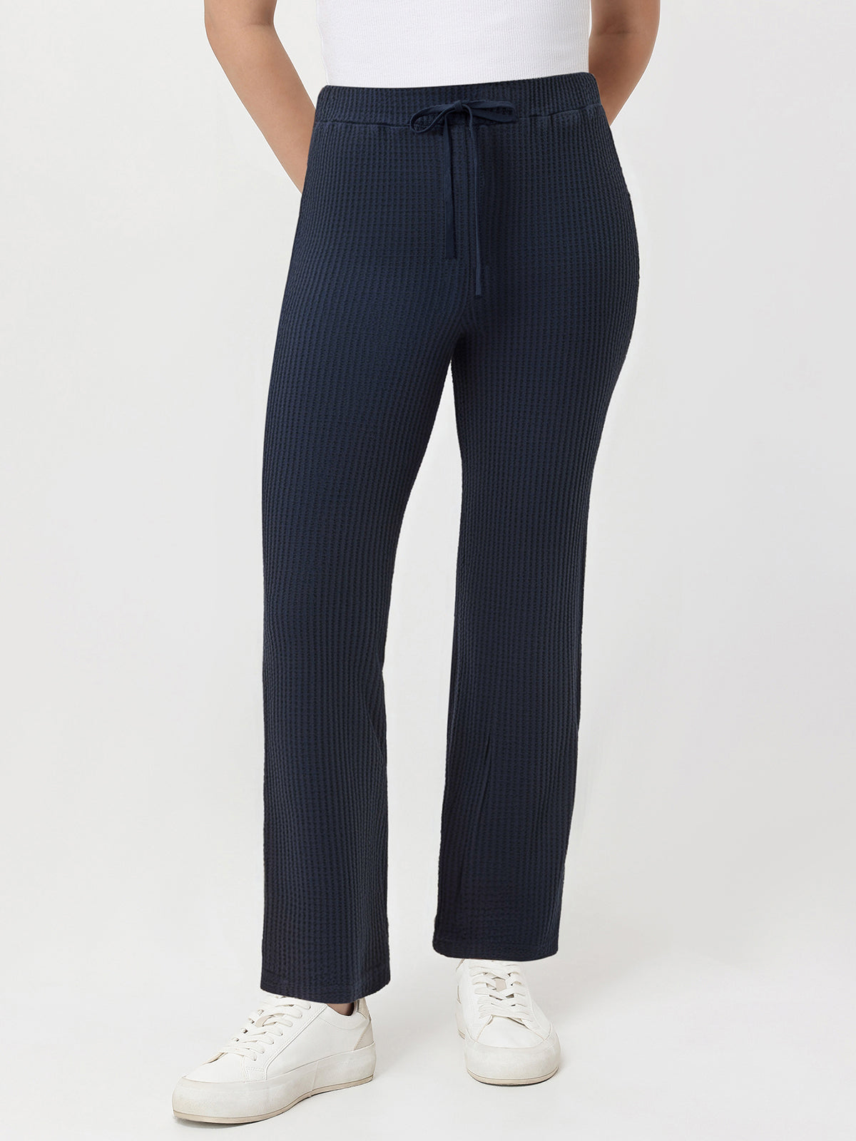 Navy waffle pants worn by a person on a white background