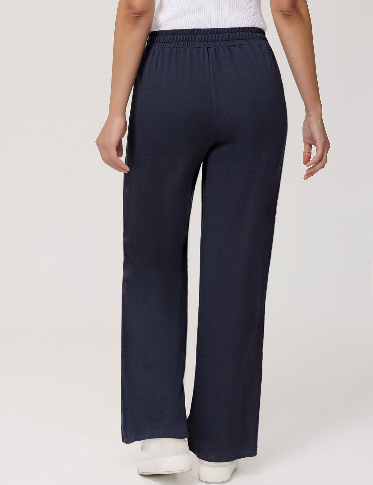 Navy blue pants worn by a person on a white background