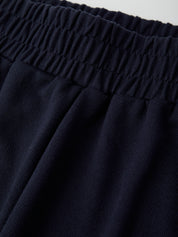 Close-up of dark blue pants with an elastic waistband.