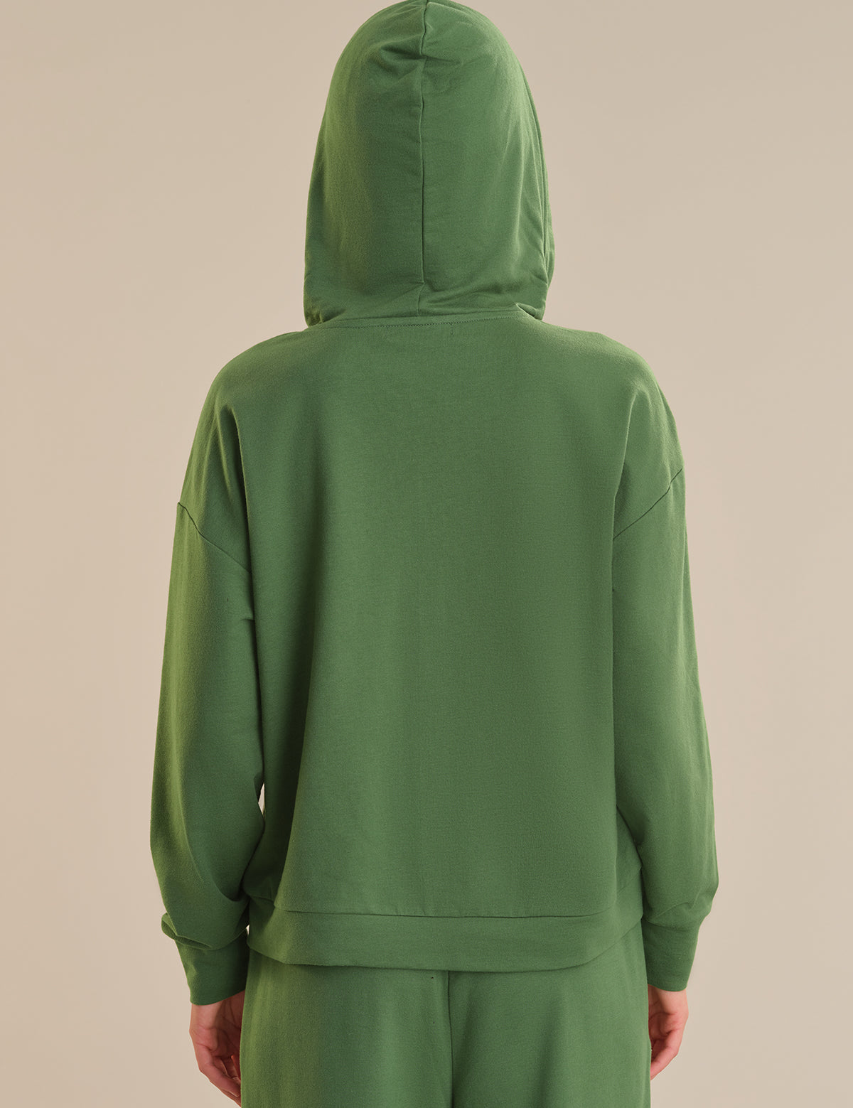 Green hoodie on a beige background