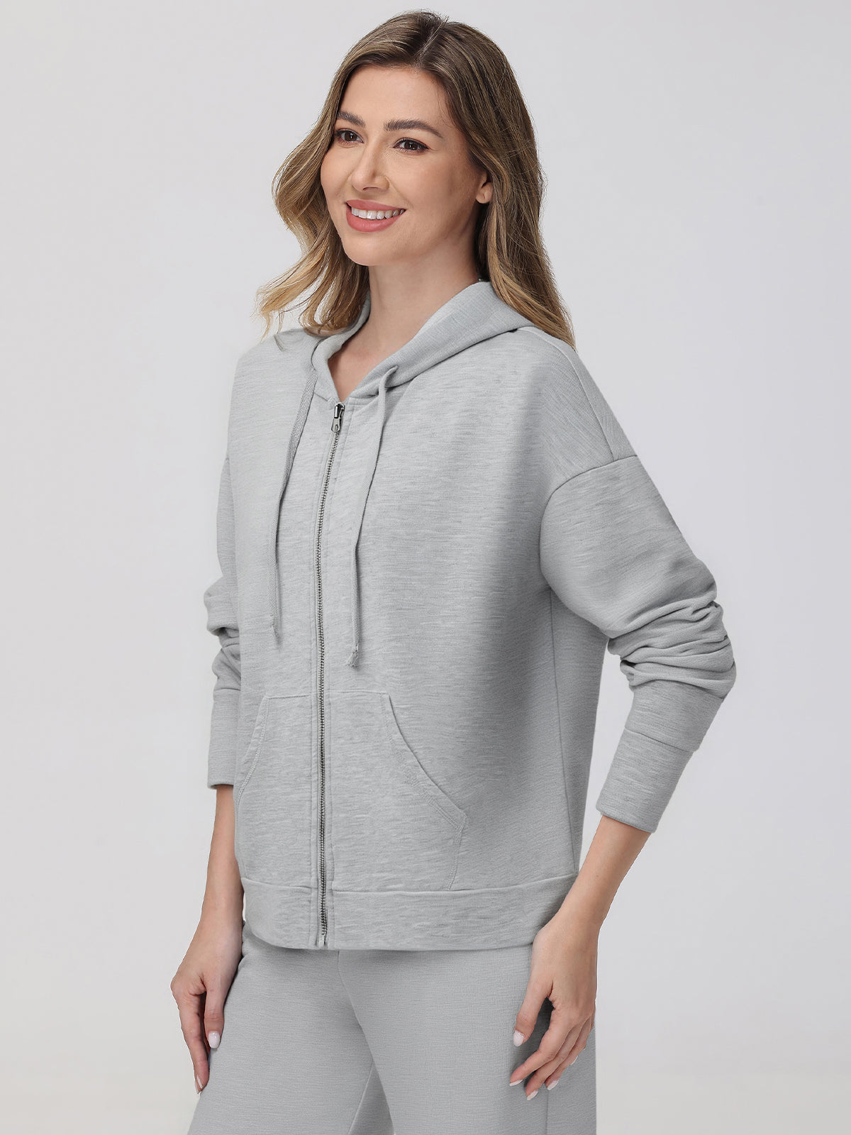 Woman wearing a gray hoodie on a white background