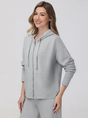 Woman wearing a gray hoodie on a white background