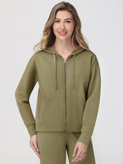 Woman wearing a green hoodie and pants on a white background