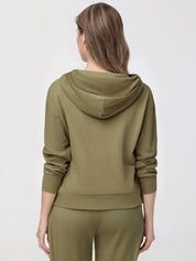 Woman wearing an olive green hoodie and pants on a white background