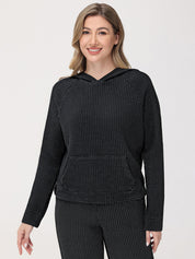 Woman wearing a black textured hoodie and pants on a white background