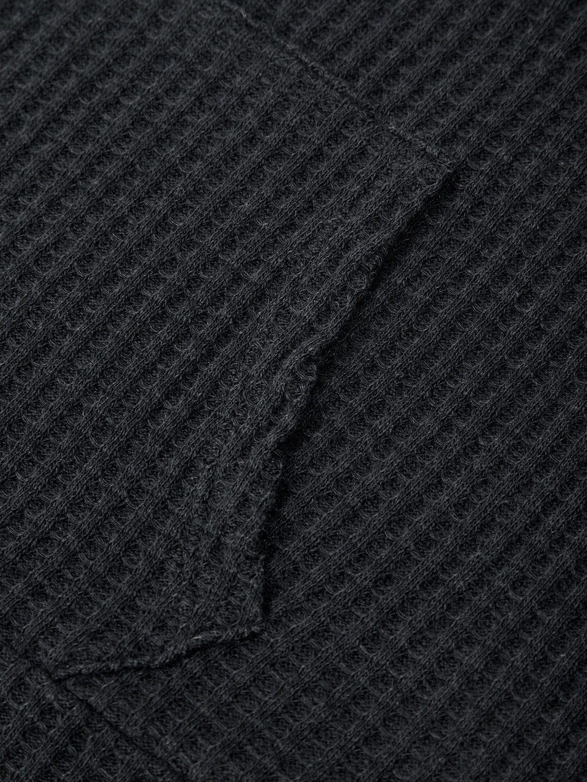Close-up of a textured black fabric with a diamond pattern