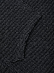 Close-up of a textured black fabric with a diamond pattern