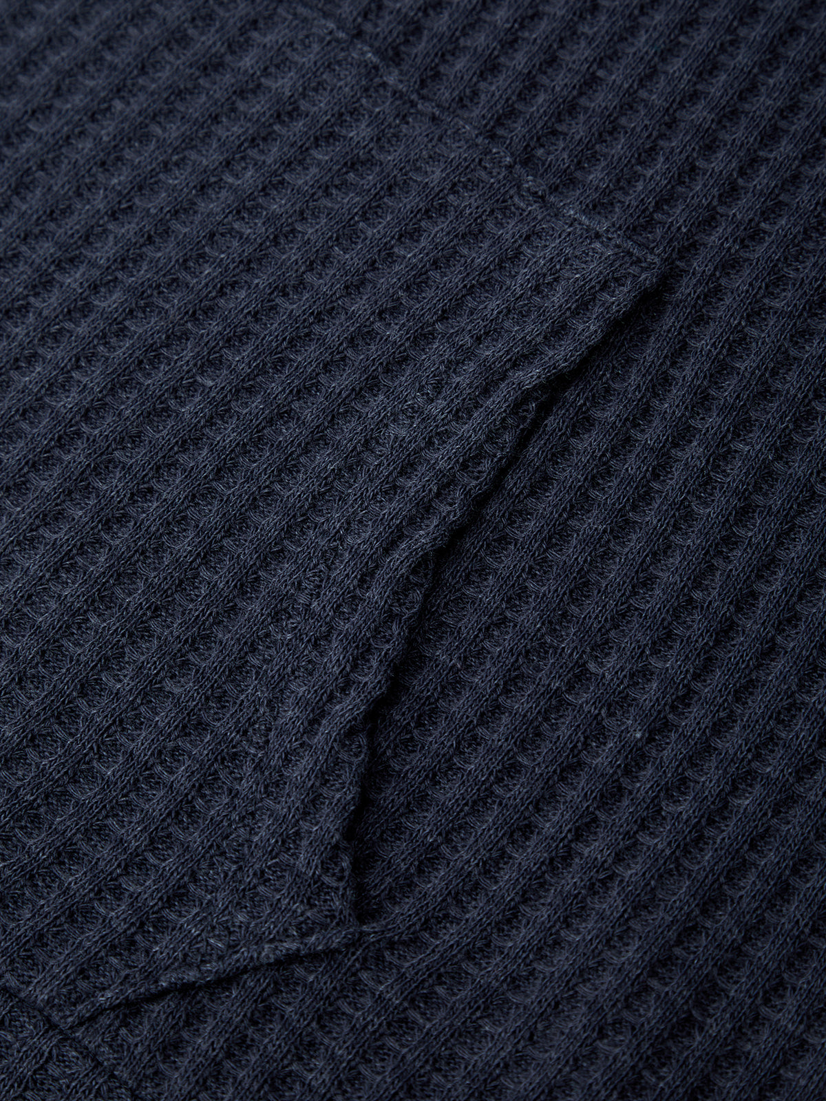 Close-up of a textured navy blue fabric with a diamond pattern