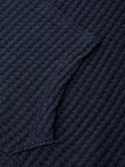 Close-up of a textured navy blue fabric with a diamond pattern