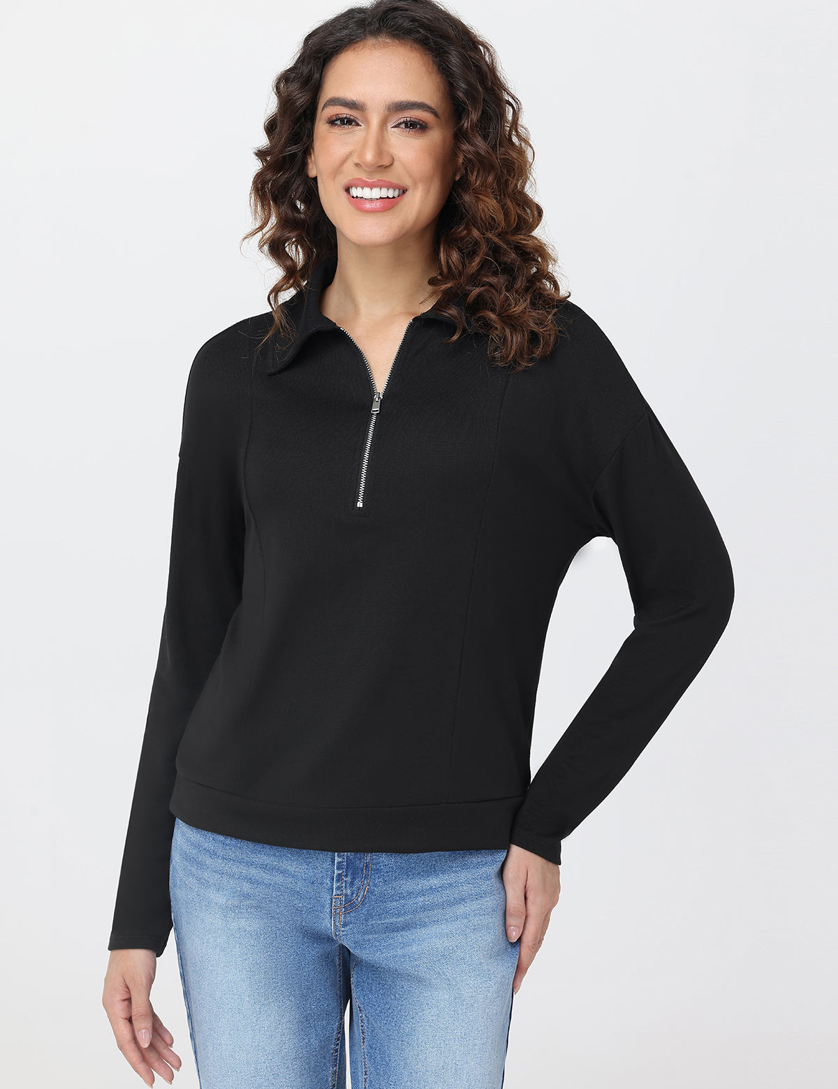Woman wearing a black long-sleeve top with a zipper on a white background