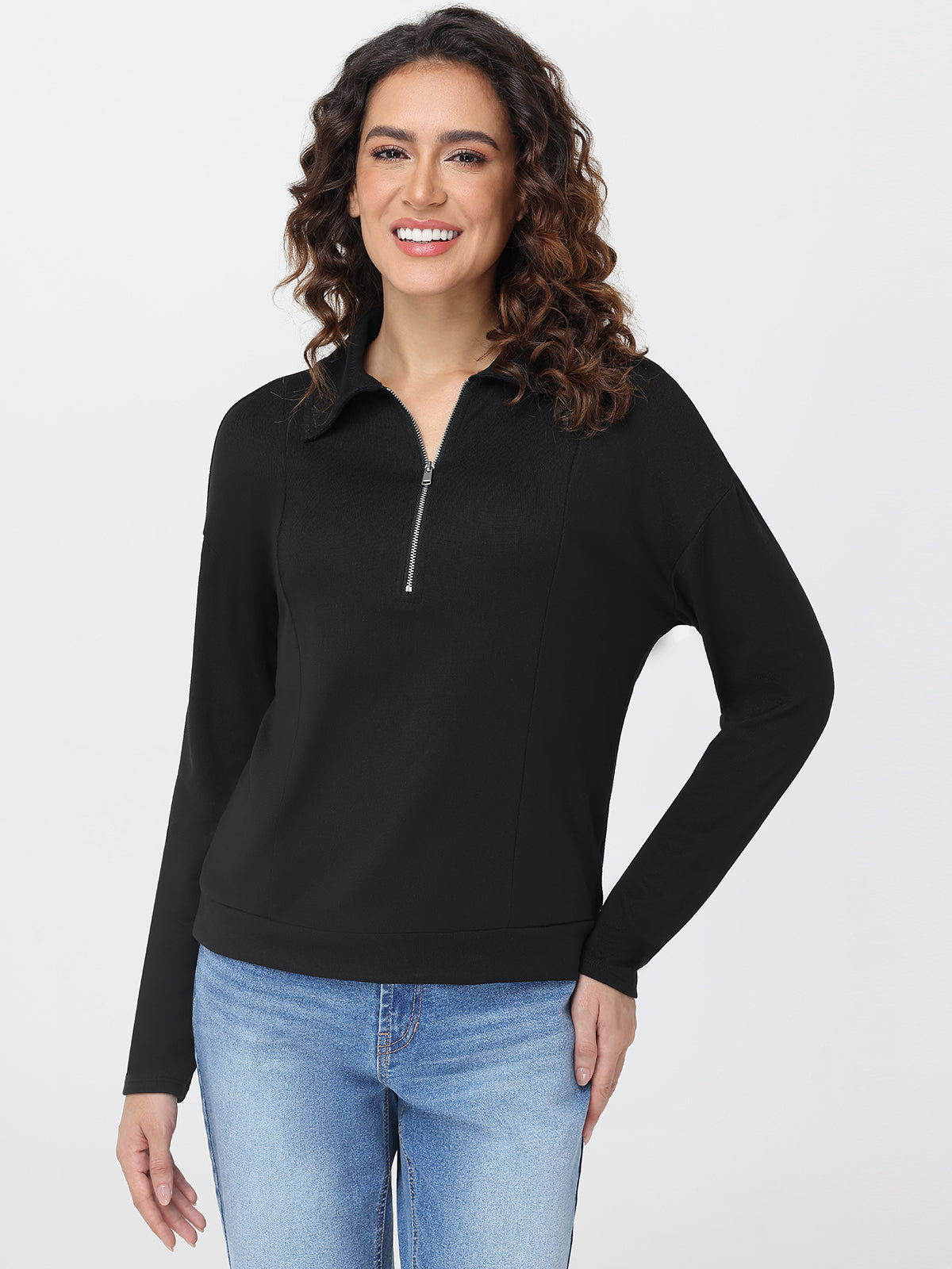 Woman wearing a black long-sleeve top with a zipper on a white background