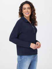 Woman wearing a navy blue pullover with a zipper on a white background