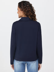 Person wearing a navy blue pullover and light blue jeans on a white background