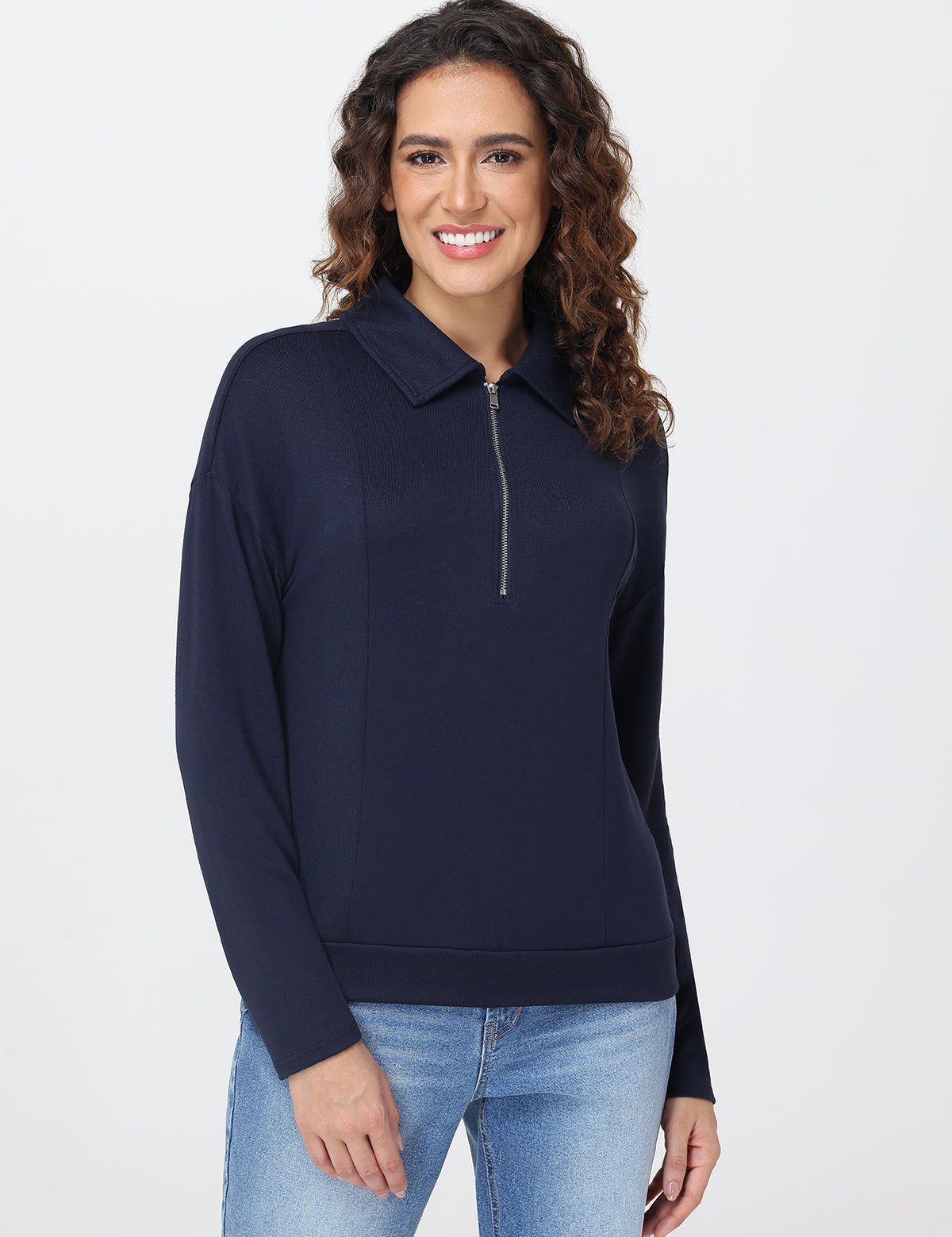 Woman wearing a navy blue long-sleeve top with a zipper on a white background