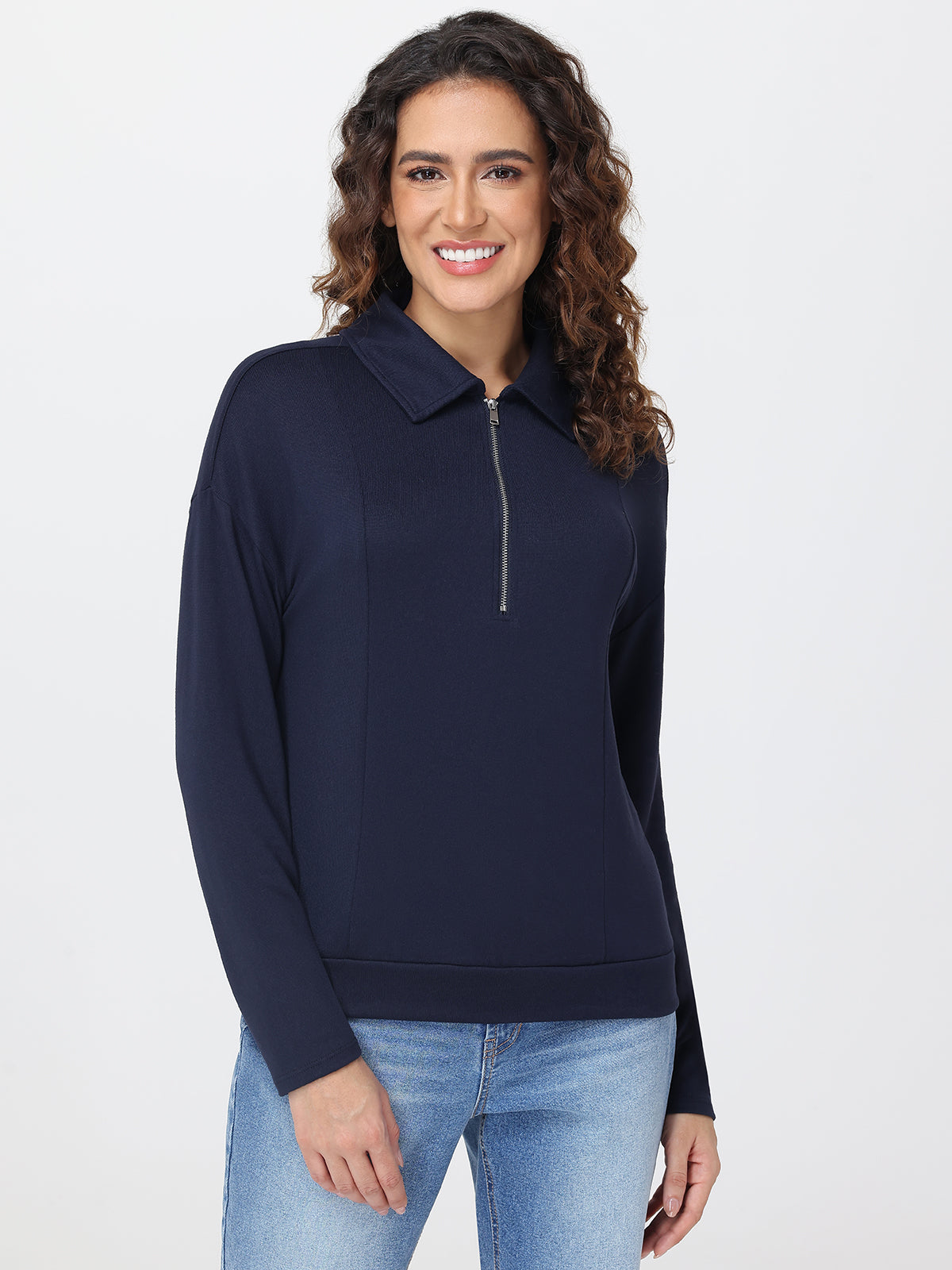 Woman wearing a navy blue long-sleeve top with a zipper on a white background