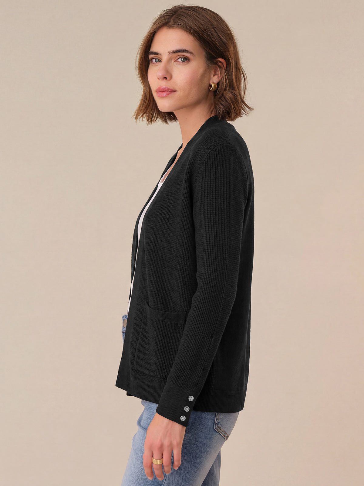 Woman wearing a black blazer against a beige background