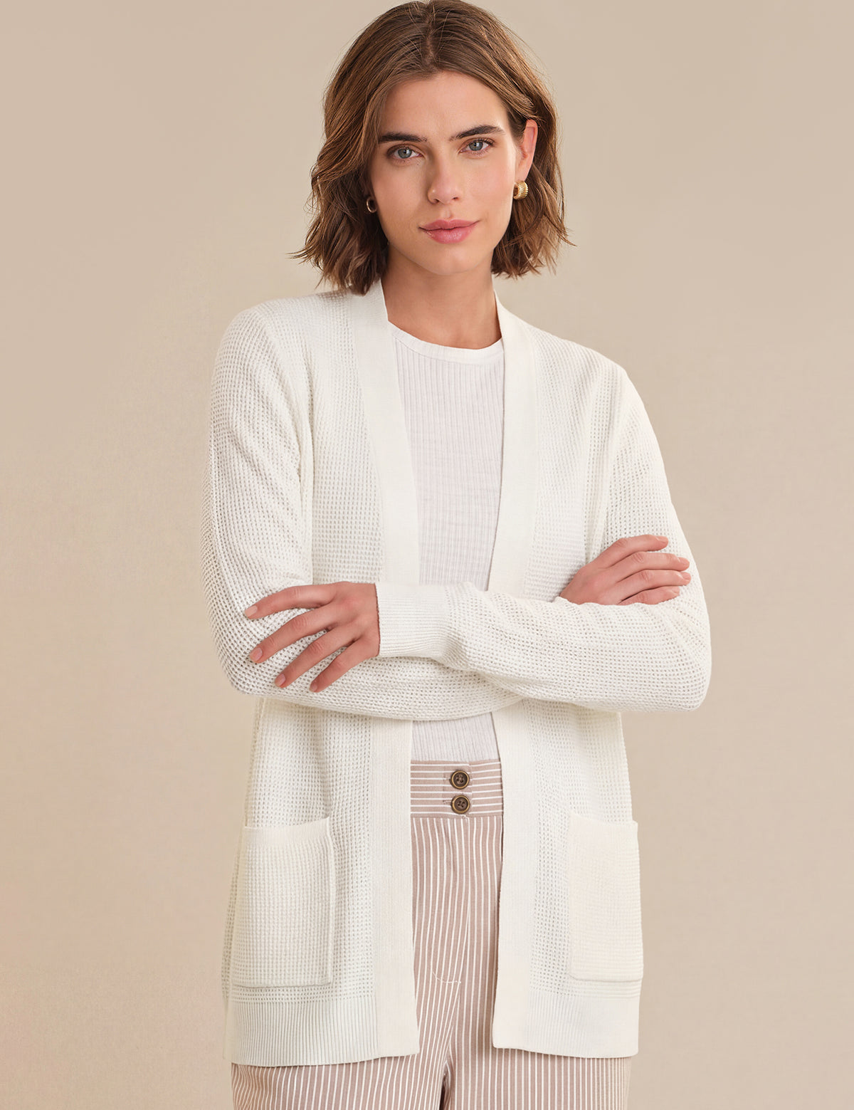 Woman wearing a white cardigan over a beige background