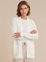 Woman wearing a white cardigan over a beige background