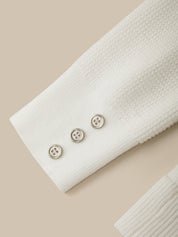 Close-up of a white textured fabric with three buttons on a beige background