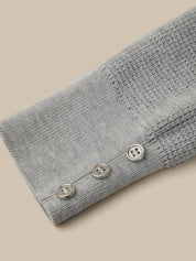 Gray knitted sleeve with buttons on a beige background