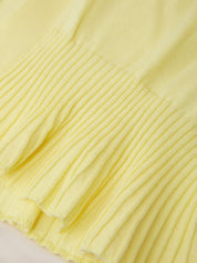 Close-up of a pale yellow ribbed knit fabric with a pleated ruffle hem detail.