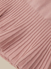 Close-up of a dusty pink ribbed knit fabric texture, showing the detailed vertical corduroy-like weave and fringed edge.