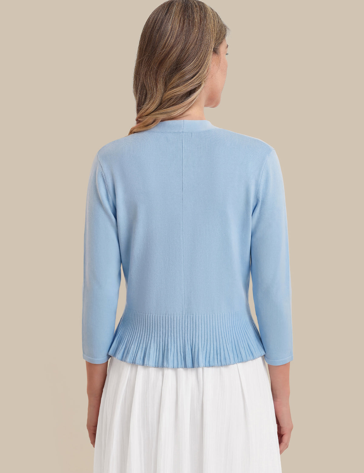 Light blue cardigan worn by a person on a beige background