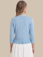 Light blue cardigan worn by a person on a beige background