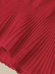 A close-up of a vibrant red ribbed knit fabric, showing the detailed vertical pleats and texture of the material.