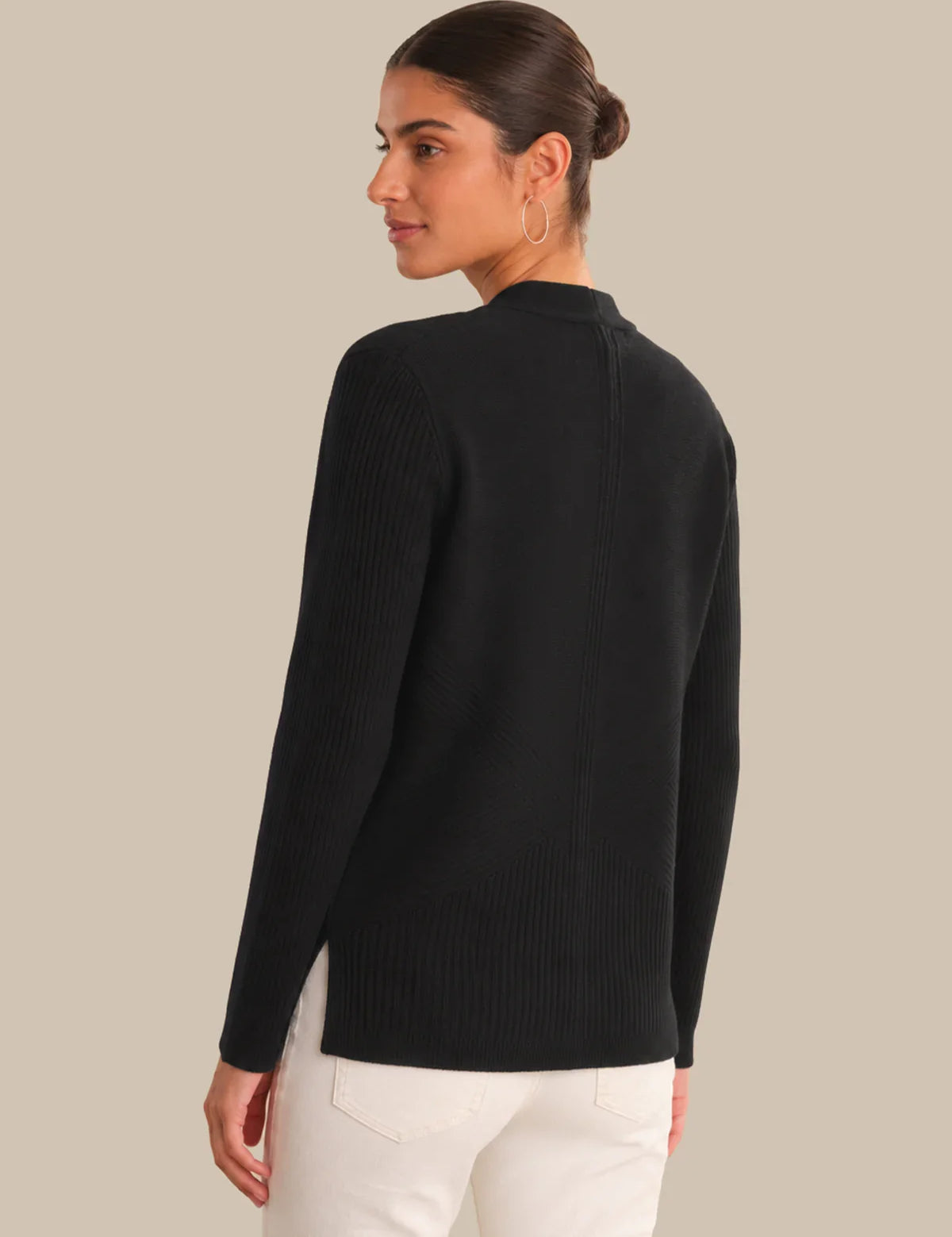 Woman wearing a black sweater on a beige background