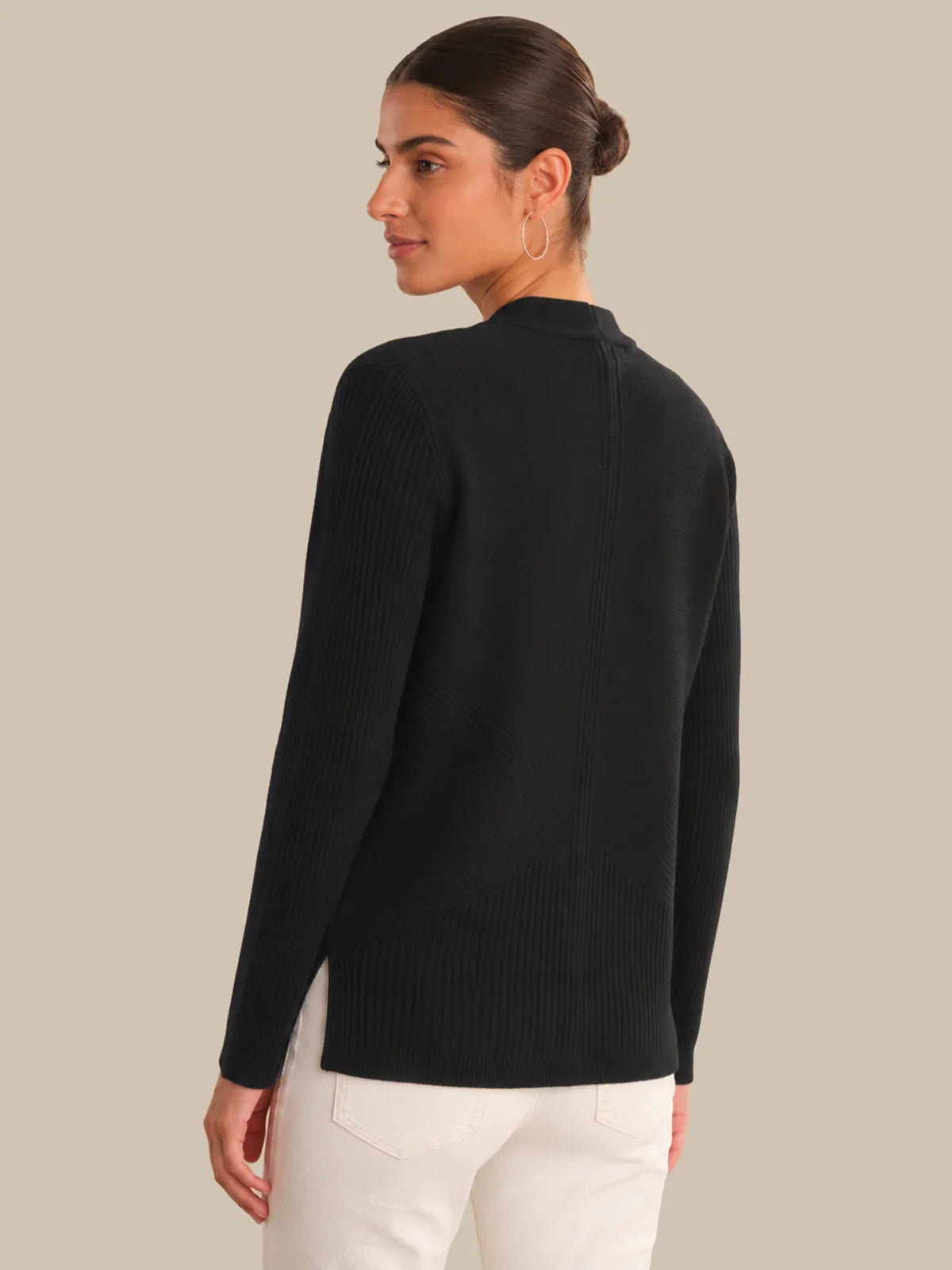 Woman wearing a black sweater on a beige background