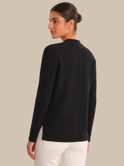 Woman wearing a black sweater on a beige background