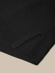 Close-up of a black ribbed sweater on a beige background