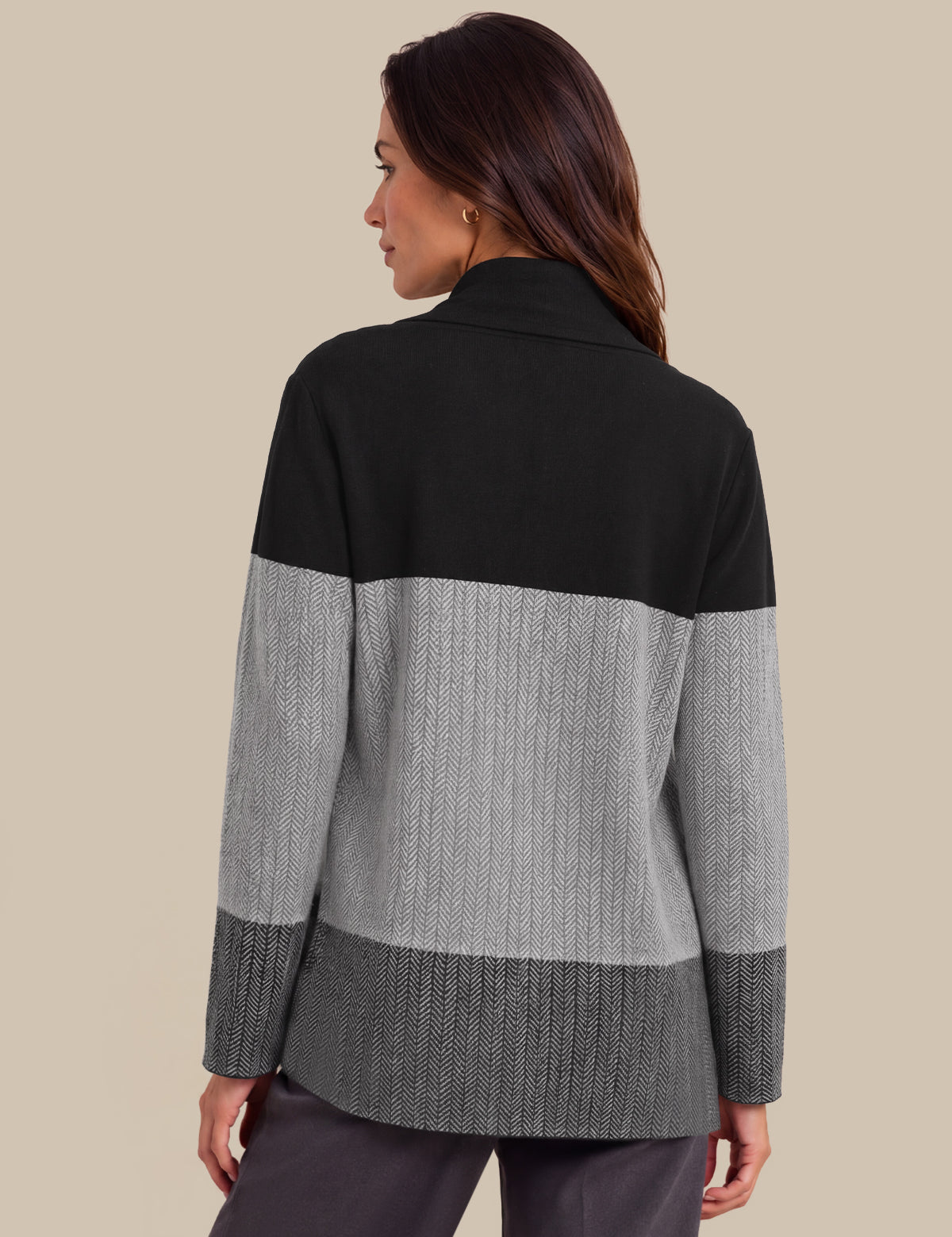 A woman shown from the back wearing a color-block knit cardigan with a black yoke, light gray middle section, and dark gray ribbed hem and cuffs, against a solid beige background.