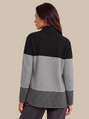 A woman shown from the back wearing a color-block knit cardigan with a black yoke, light gray middle section, and dark gray ribbed hem and cuffs, against a solid beige background.
