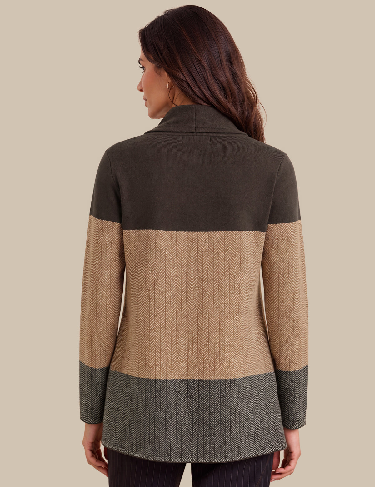A woman shown from the back wearing a color-block knit cardigan with dark olive green, tan, and gray sections against a solid beige background.