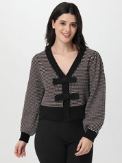 Woman wearing a chocolate and white patterned cardigan on a white background