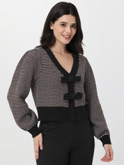 Woman wearing a chocolate and white patterned cardigan on a white background