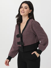 Woman wearing a patterned cardigan with a deep garnet accent on a white background