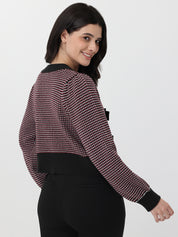 Woman wearing a patterned long-sleeve cardigan with deep garnet accents on a white background