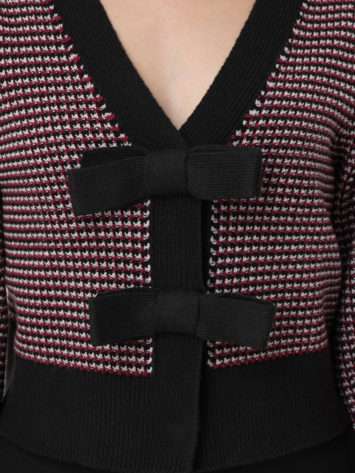 Close-up of a textured garment with a black bow detail