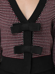 Close-up of a textured garment with a black bow detail