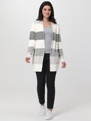 Woman wearing a striped cardigan over a gray top and black pants on a white background