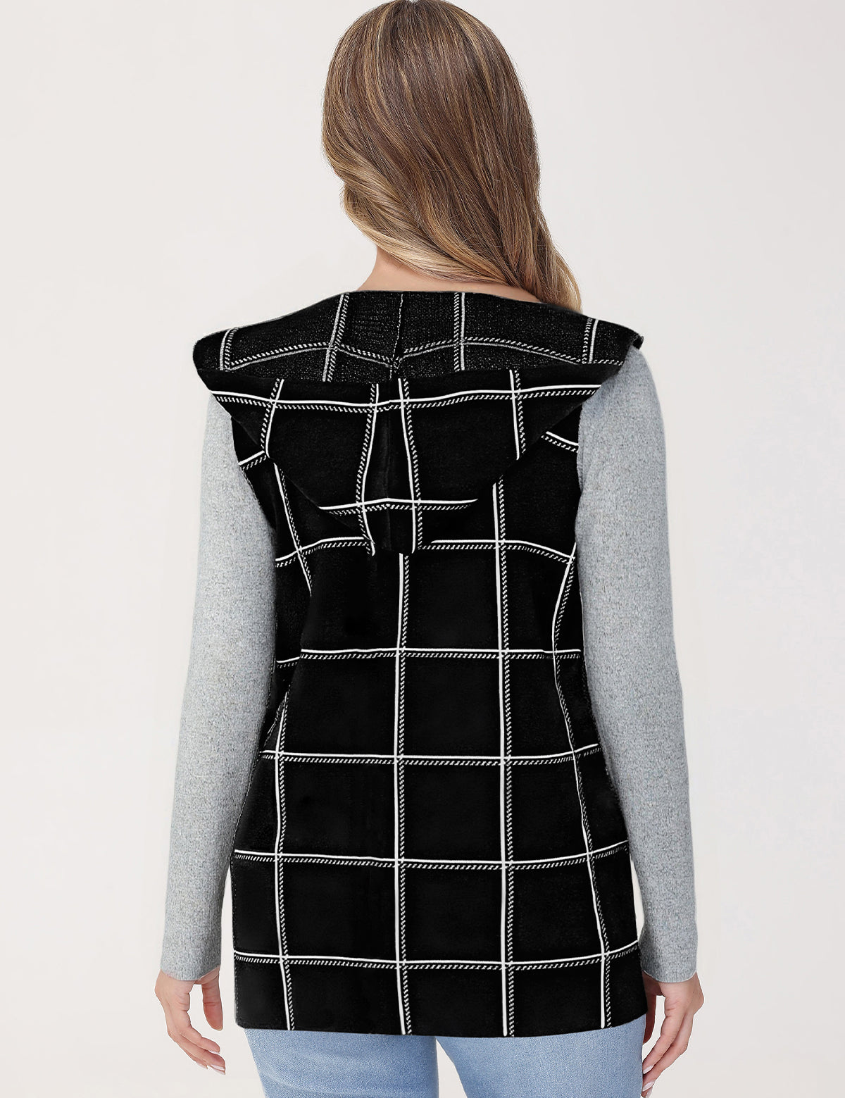 Person wearing a black checkered vest on a light gray background