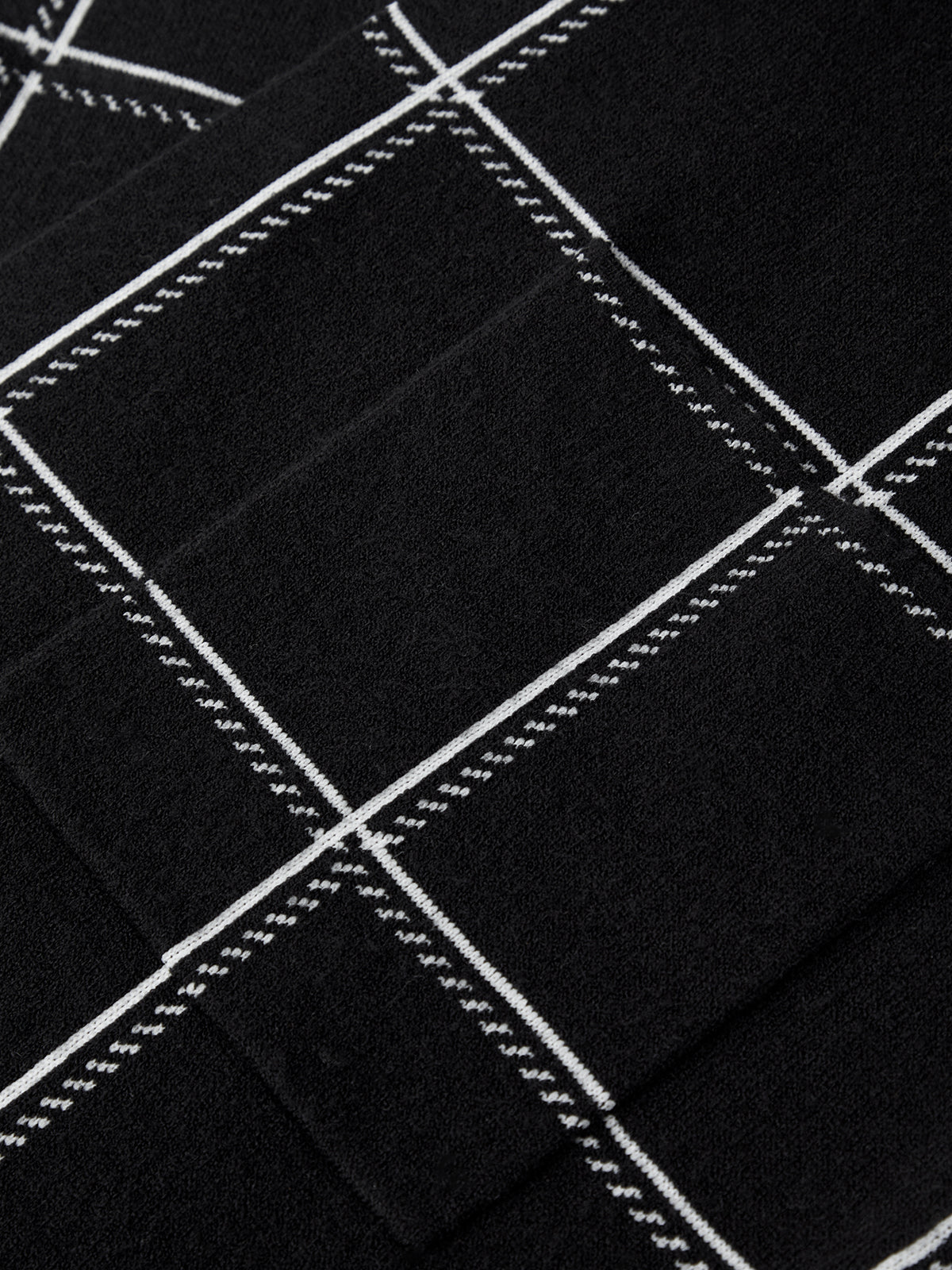 Close-up of black fabric with white stitching patterns
