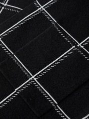 Close-up of black fabric with white stitching patterns