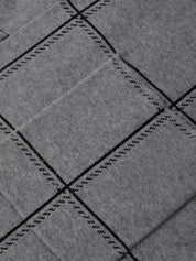 Close-up of gray fabric with black stitching pattern