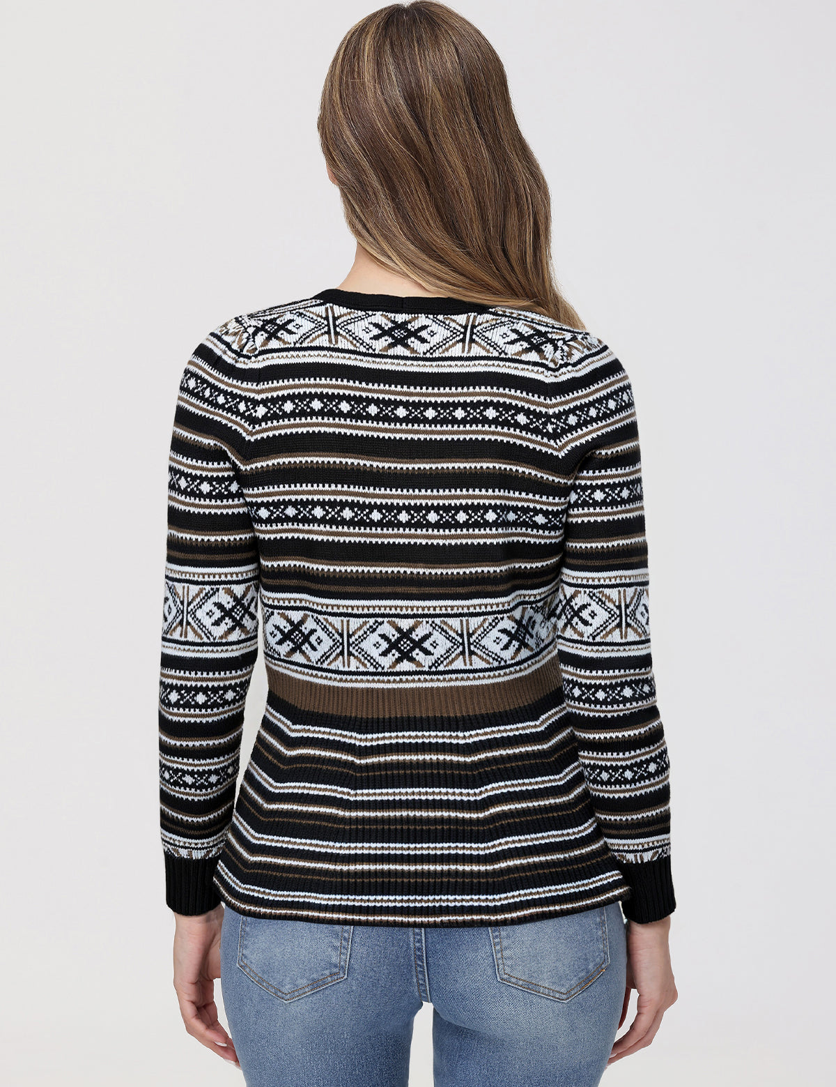 Person wearing a black patterned sweater on a plain background